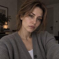 Женщина сидит дома в кардигане, усталое лицо